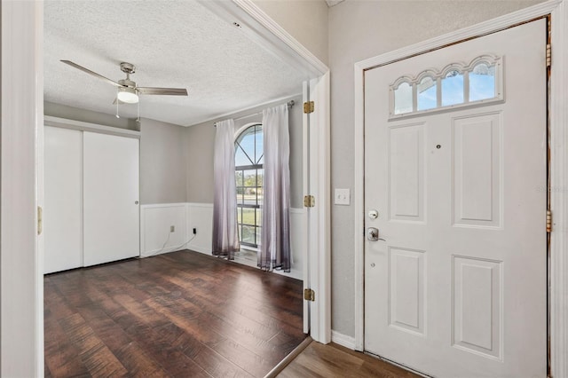 entryway with ceiling fan, dark hardwood / wood-style flooring, and a textured ceiling