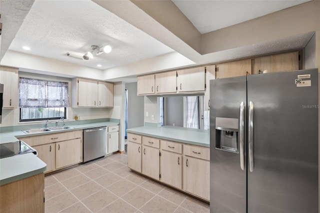 kitchen with sink, stainless steel appliances, a textured ceiling, light brown cabinetry, and light tile patterned floors