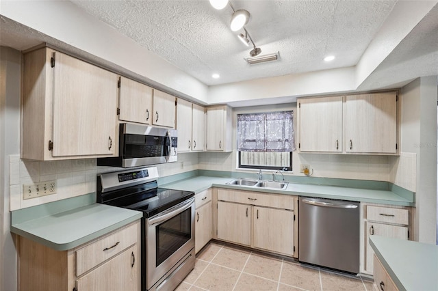 kitchen with light brown cabinetry, decorative backsplash, sink, and appliances with stainless steel finishes