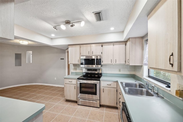 kitchen featuring appliances with stainless steel finishes, light brown cabinetry, a textured ceiling, sink, and light tile patterned floors