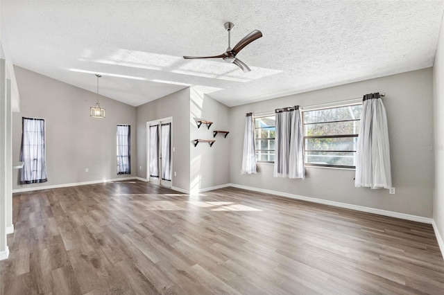 unfurnished room with wood-type flooring, a textured ceiling, ceiling fan, and lofted ceiling