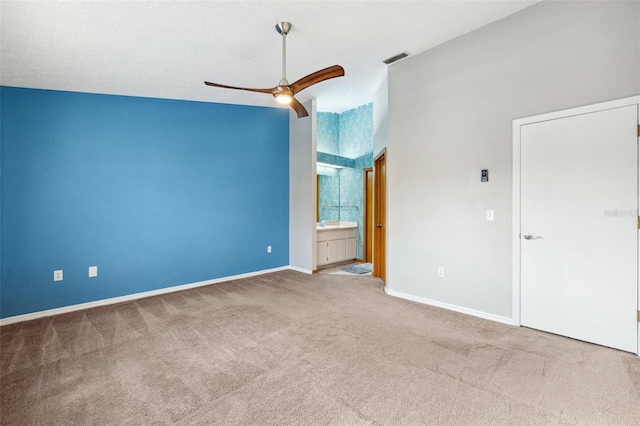 carpeted spare room with ceiling fan, a textured ceiling, and vaulted ceiling