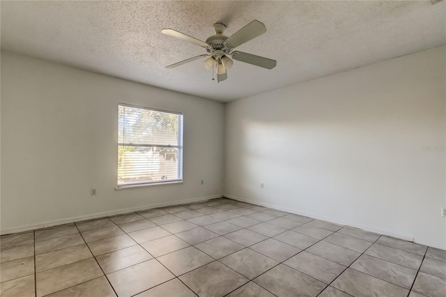 empty room featuring ceiling fan, light tile patterned floors, and a textured ceiling