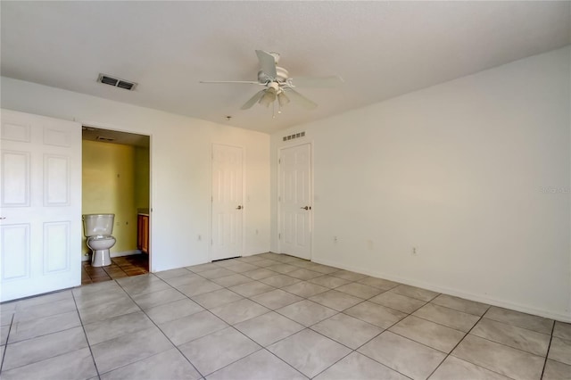 tiled empty room with ceiling fan