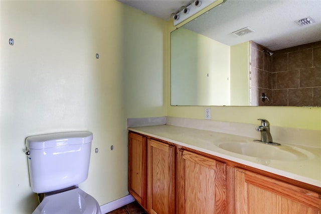 bathroom featuring tile patterned flooring, a textured ceiling, vanity, and toilet