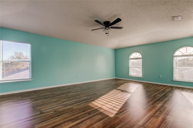 unfurnished room featuring ceiling fan, dark hardwood / wood-style flooring, and a textured ceiling