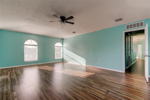 empty room featuring ceiling fan, dark hardwood / wood-style flooring, and a textured ceiling