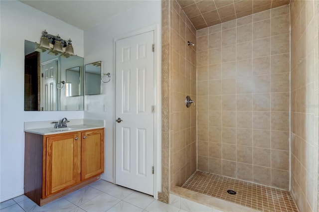 bathroom featuring tile patterned floors, vanity, and a tile shower