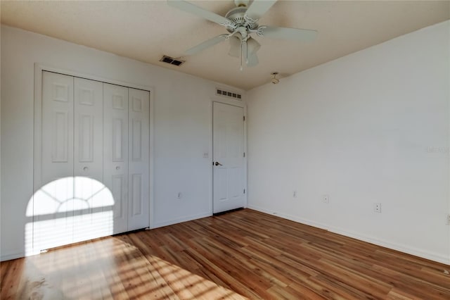 unfurnished bedroom featuring wood-type flooring, a closet, and ceiling fan