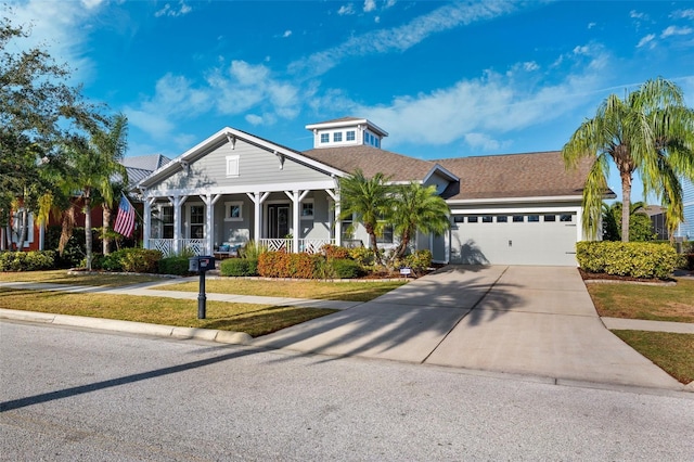 view of front of property featuring a front lawn, a porch, and a garage