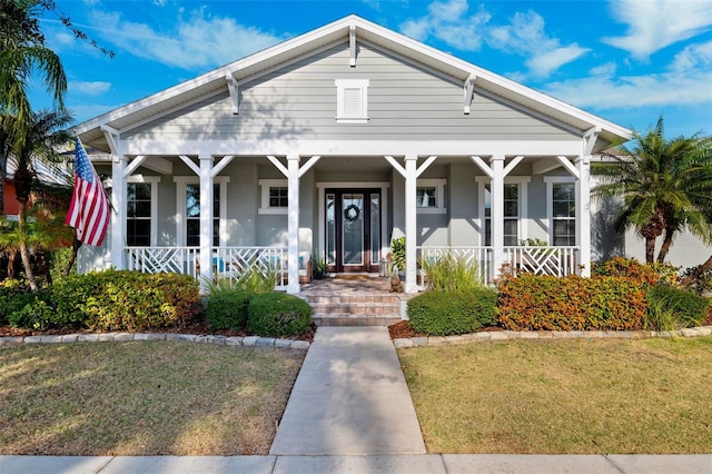 bungalow featuring a porch and a front lawn