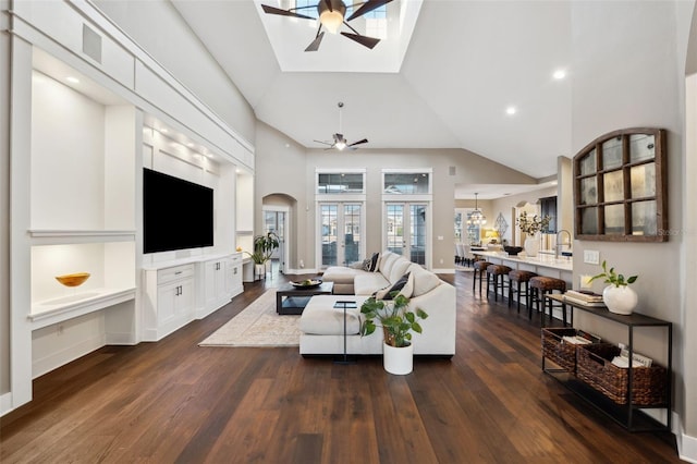 living room with ceiling fan, dark hardwood / wood-style floors, and high vaulted ceiling