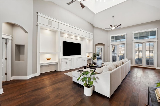 living room featuring ceiling fan, dark hardwood / wood-style floors, and a high ceiling