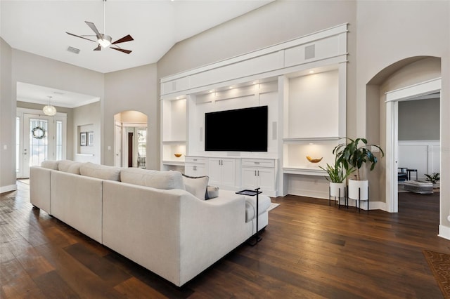 living room featuring dark wood-type flooring, high vaulted ceiling, and ceiling fan