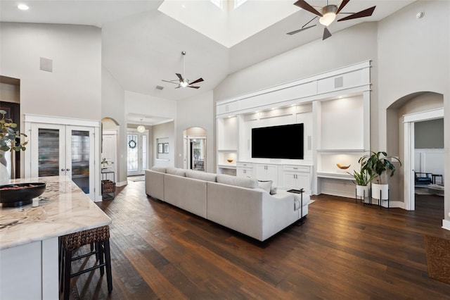 living room featuring dark hardwood / wood-style flooring, high vaulted ceiling, french doors, and ceiling fan