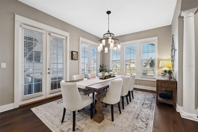 dining area with dark hardwood / wood-style floors, a chandelier, and ornate columns