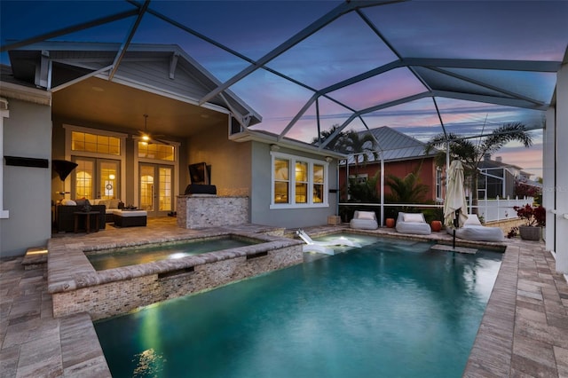 pool at dusk with a lanai, ceiling fan, a patio, an outdoor living space, and an in ground hot tub