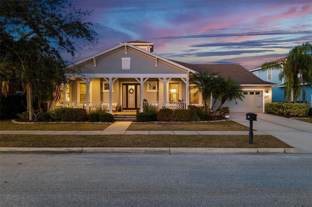 view of front of property with stucco siding, covered porch, concrete driveway, and an attached garage