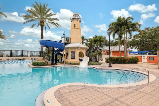 view of pool with a water slide and a patio area