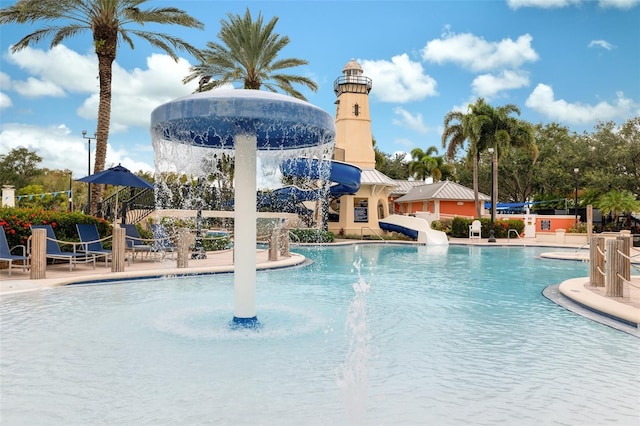 view of swimming pool with pool water feature and a water slide