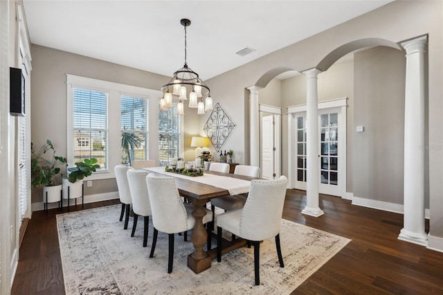 dining space with visible vents, dark wood-type flooring, baseboards, decorative columns, and arched walkways