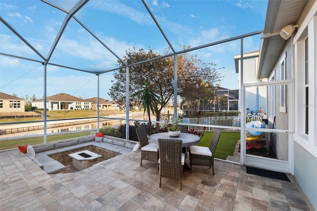 sunroom with a residential view and a water view