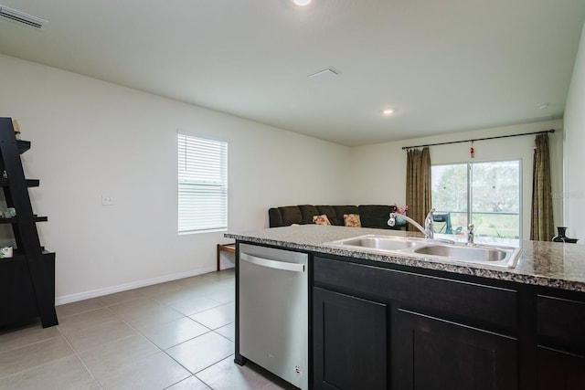 kitchen featuring sink, light tile patterned floors, dishwasher, and stone countertops