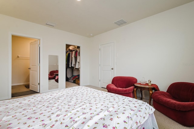 bedroom with light colored carpet, a spacious closet, and a closet