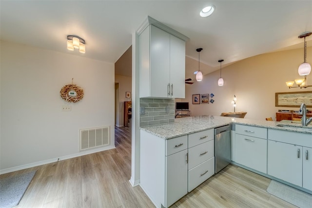 kitchen with pendant lighting, backsplash, stainless steel dishwasher, and sink