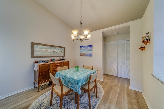 dining area with light hardwood / wood-style flooring and a chandelier