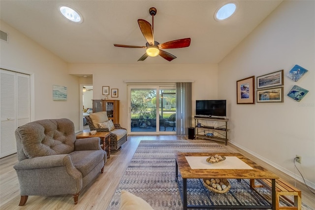 living room featuring ceiling fan, lofted ceiling, and light hardwood / wood-style flooring