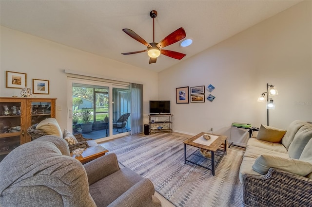 living room with hardwood / wood-style flooring, vaulted ceiling, and ceiling fan