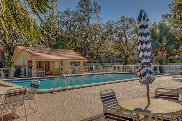 view of pool with an outbuilding and a patio