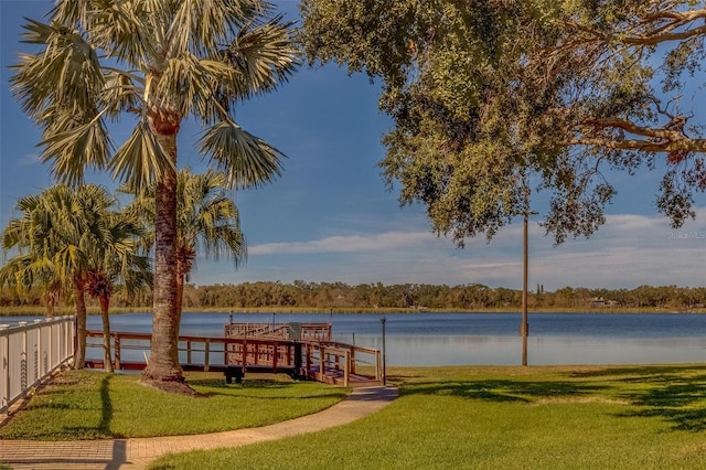 view of dock featuring a lawn and a water view