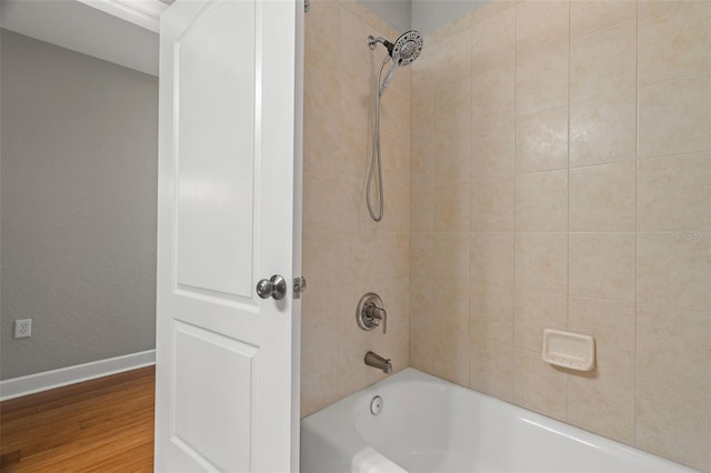 bathroom with hardwood / wood-style flooring and tiled shower / bath combo