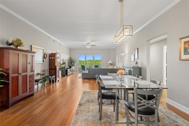 dining area featuring ceiling fan, light wood-type flooring, and crown molding