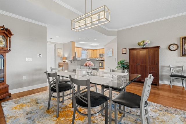 dining room featuring light hardwood / wood-style flooring and ornamental molding