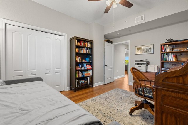 bedroom with ceiling fan, light wood-type flooring, and a closet