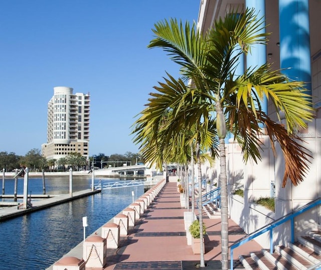 view of swimming pool featuring a water view and a dock