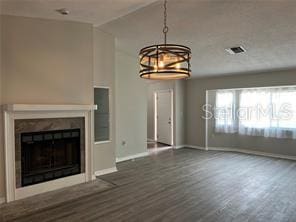 unfurnished living room with a notable chandelier and dark wood-type flooring