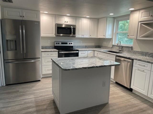 kitchen with white cabinetry, sink, a kitchen island, and stainless steel appliances