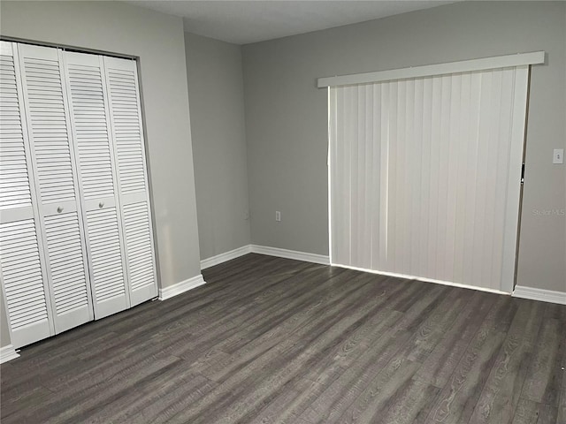 unfurnished bedroom featuring dark hardwood / wood-style flooring and a closet