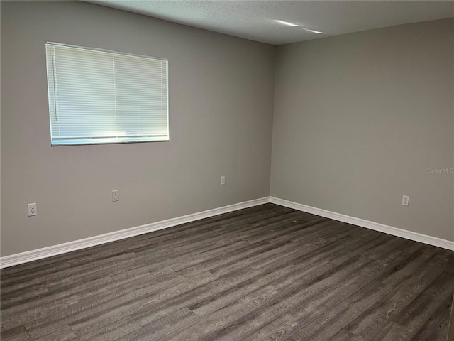 unfurnished room with dark hardwood / wood-style flooring and a textured ceiling