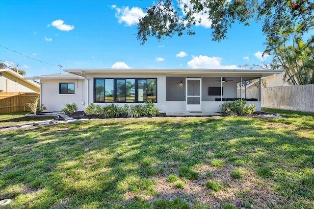 rear view of house with a sunroom and a yard