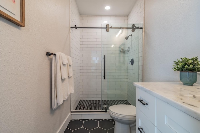 bathroom featuring tile patterned floors, vanity, toilet, and a shower with shower door