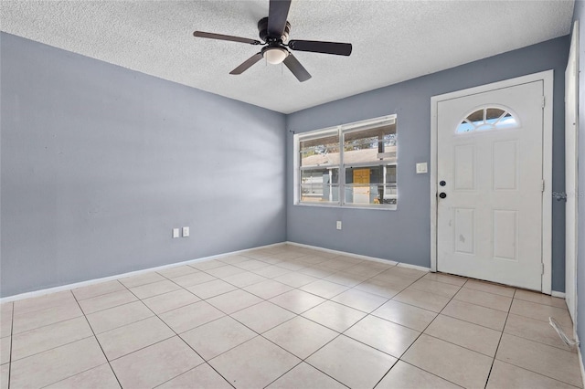 tiled foyer with ceiling fan and a textured ceiling