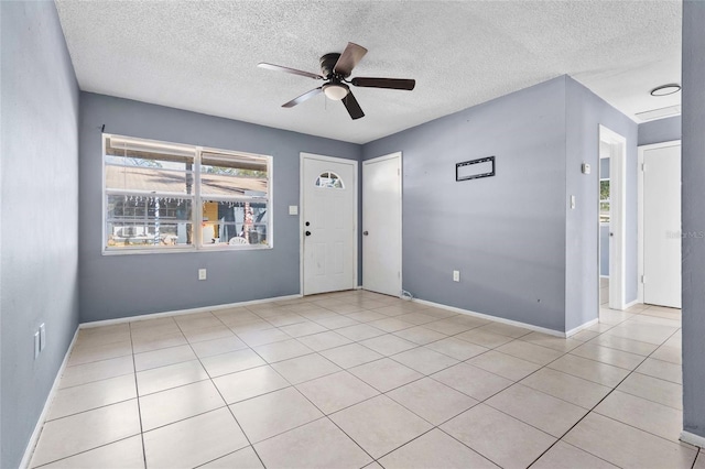 foyer with a textured ceiling, light tile patterned floors, and ceiling fan