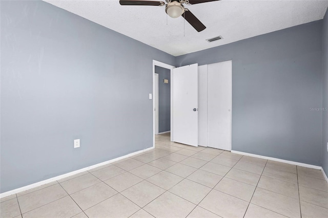 spare room with ceiling fan and light tile patterned flooring