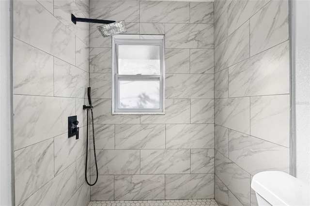 bathroom featuring tiled shower and toilet