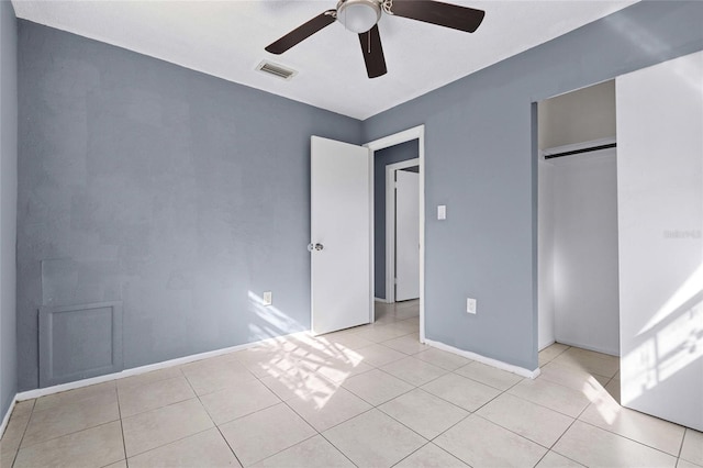 unfurnished bedroom with ceiling fan, light tile patterned floors, and a closet